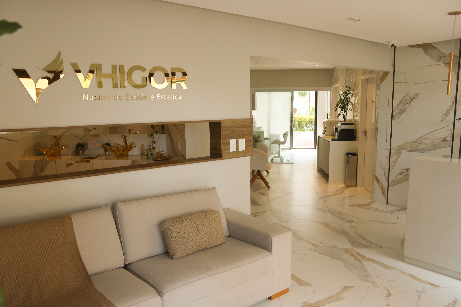 Recepção da Clínica Núcleo Vhigor com logo dourado e ambiente acolhedor